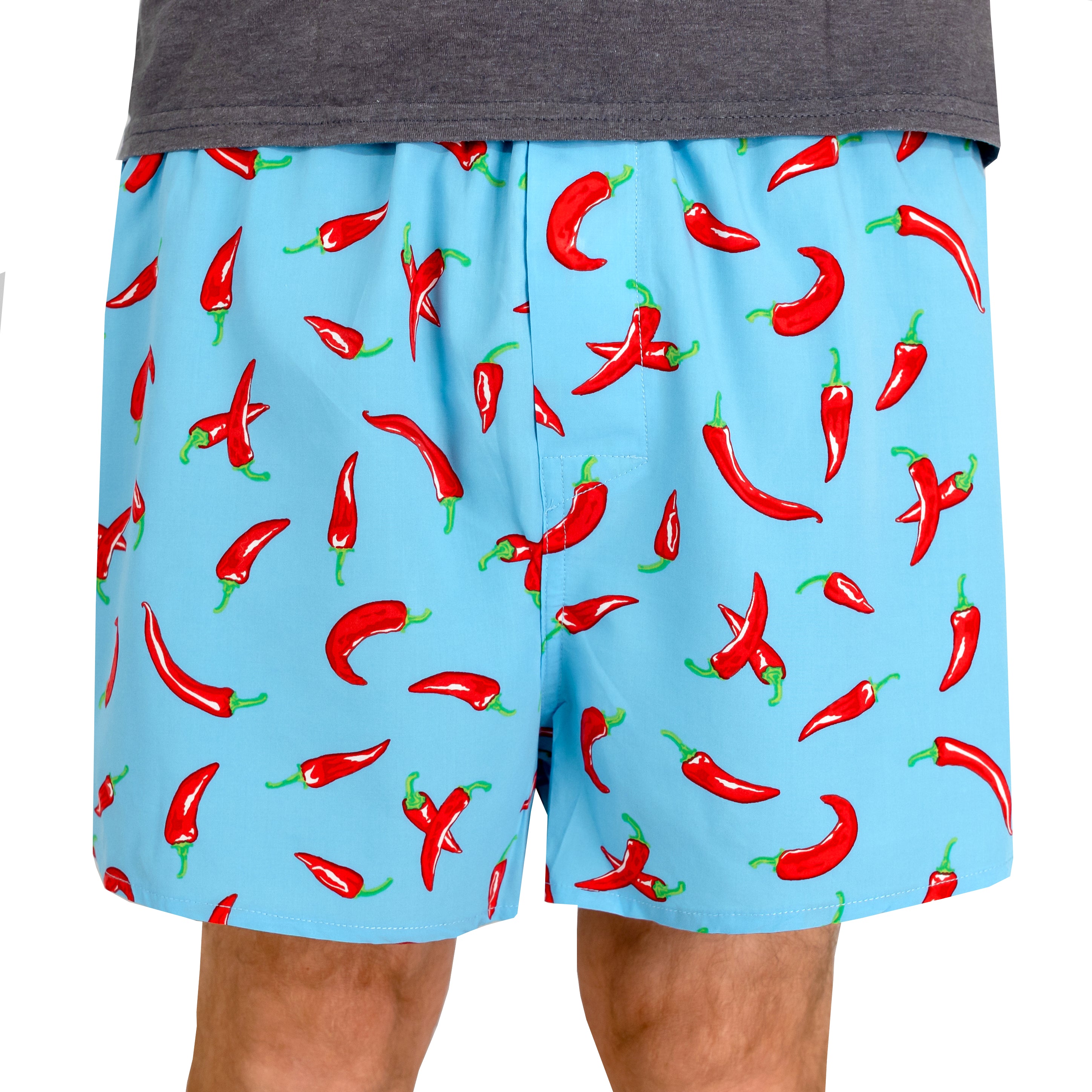 A person wearing light blue boxer-brief style shorts covered in a red chili pepper print, shown from the waist to mid-thigh against a plain white background.