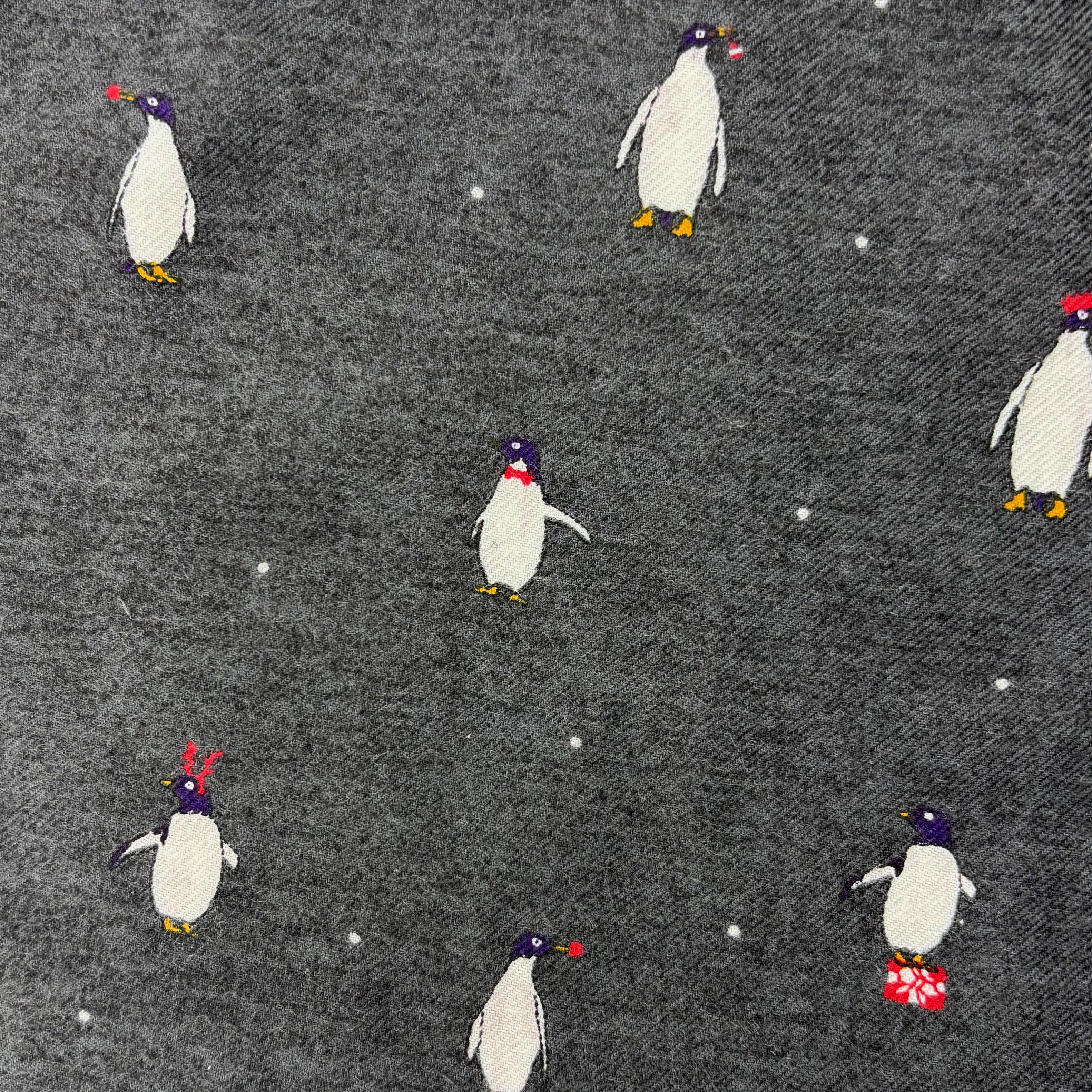 Pattern of penguins with colorful hats on a gray background