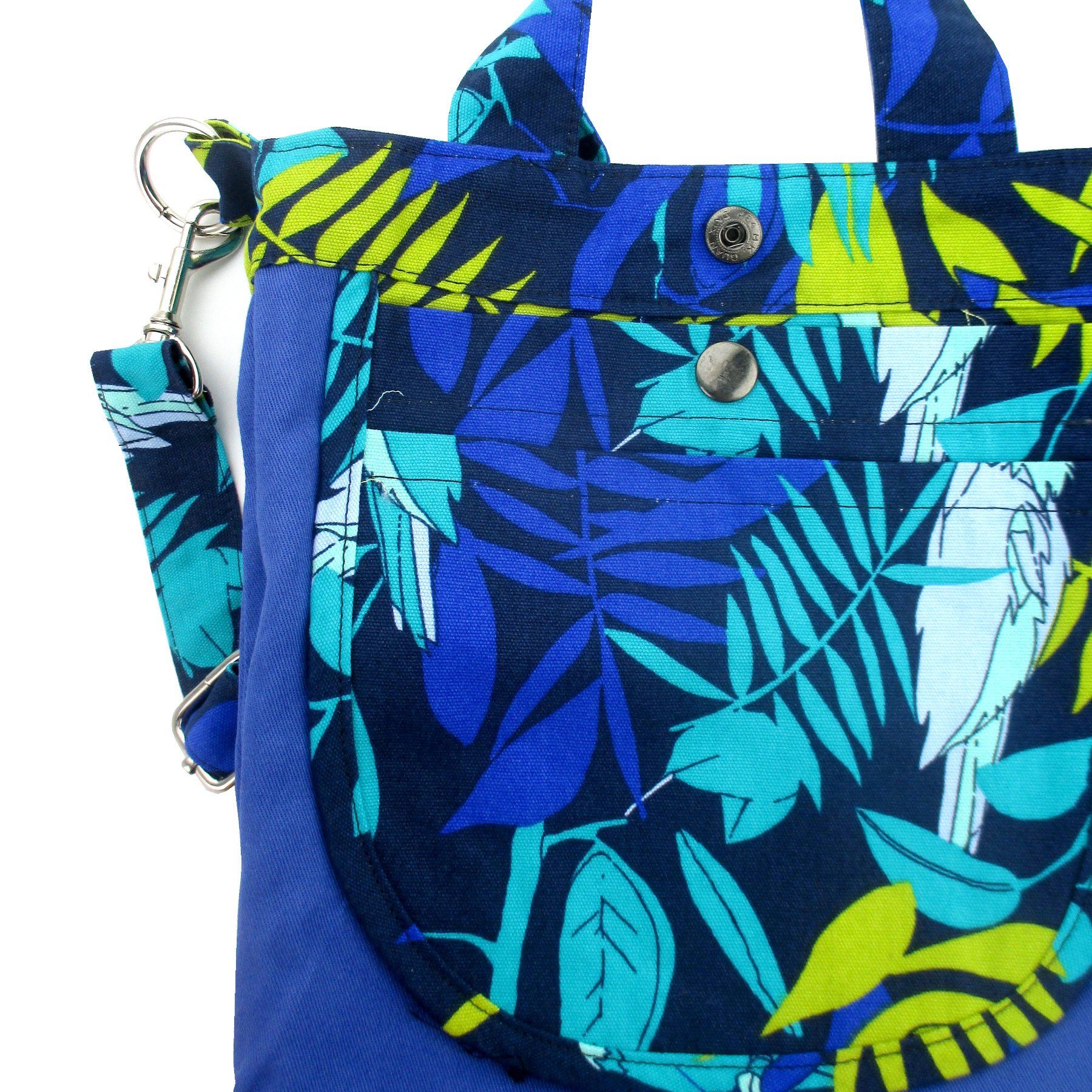 This jungle inspired bag features a blue green print made up of parrots and toucans against tropical leaves in the background.